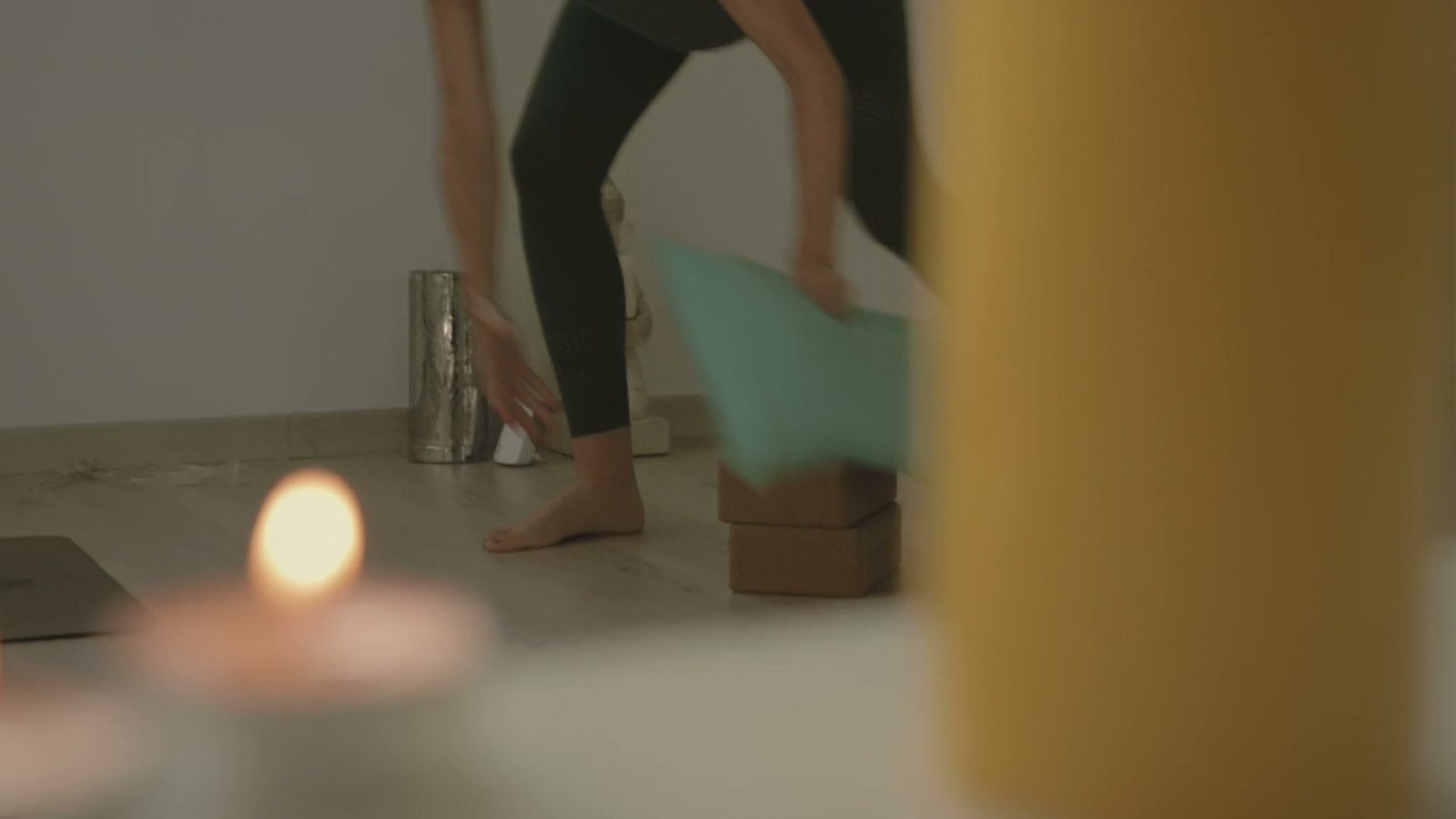 Ana coloca un cojín en la sala, detrás de unas velas encendidas