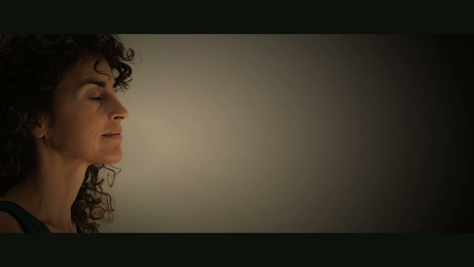 Ana de perfil con los ojos cerrados, a la luz de una vela